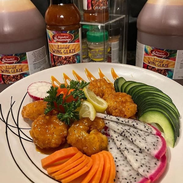 A plate of Lucid Wing Glaze chicken with dragon fruit, avocado, carrots, and radishes.