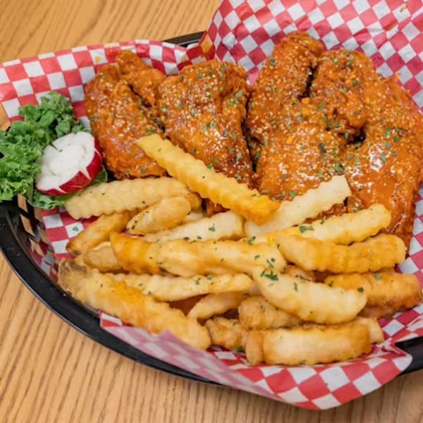 CJF Lucid Creations' chicken wings and crinkle-cut fries in a basket with red and white checkered paper.
